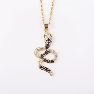 Detailopname van gouden slangenhanger met micro-pave kristallen en zwart emaille details