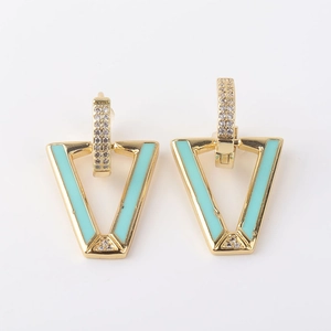 Detalle de pendientes geométricos dorados con esmalte verde menta y piedras de circonita