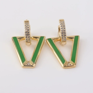 Detalle macro de pendientes en V dorados con esmalte verde y cristales finos