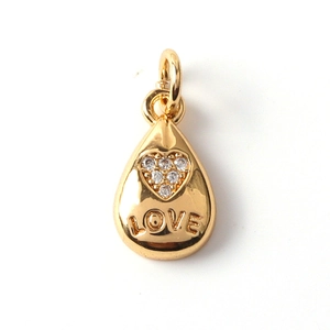 Detail of gold teardrop pendant with zircon heart inlay and engraved LOVE lettering