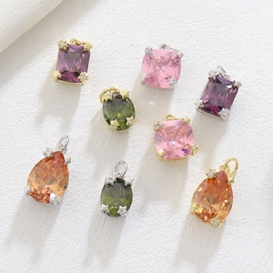 Macro detail of colorful zircon charms with star-shaped prongs and teardrop cuts