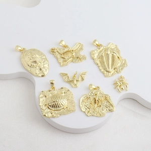 Detailed close-up of 18k gold-plated dinosaur fossil and insect pendants on a cloud stand