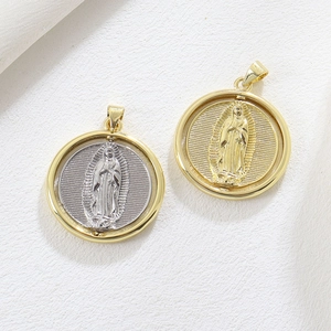 Macro detail of two-tone gold and silver religious Guadalupe medallion pendants on fabric