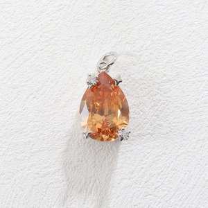 Detailed view of pear-shaped orange zircon pendant with star-shaped silver prongs