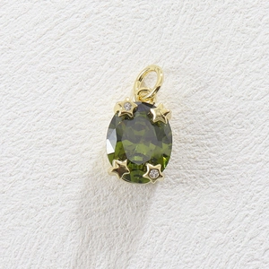 Macro view of gold plated copper pendant with olive green oval stone and star settings