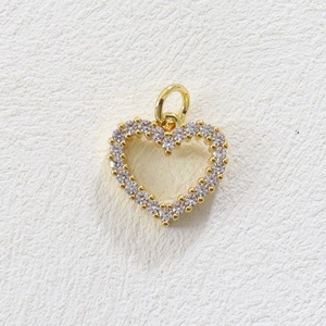 Detailed view of heart-shaped pendant with gold plating and paved white crystals