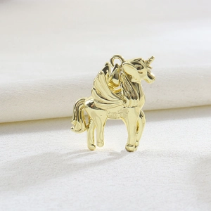 Detailed view of an 18k gold plated flying pegasus pendant with intricate wing carvings