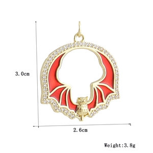 Detail view of a round gold-plated bat pendant with zircon stones and enamel wings