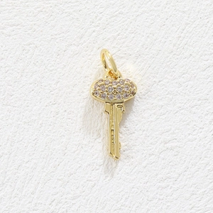 Close-up of gold-plated key pendant with shimmering micro-pave crystals and ring clasp