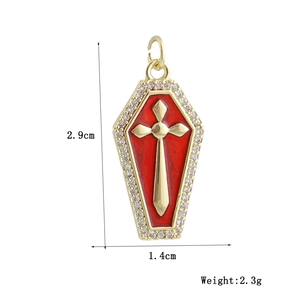 Macro shot of gold coffin pendant with red enamel, cross, and zircon stones, 2.9cm x 1.4cm