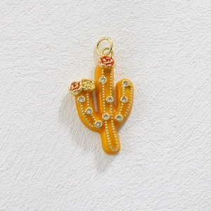 Detailed view of a gold cactus pendant with orange enamel and sparkling zircon stones
