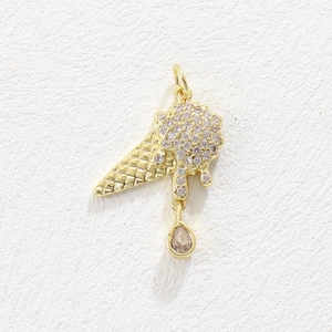 Macro shot of 18k gold ice cream pendant with pave zircon stones and teardrop crystal