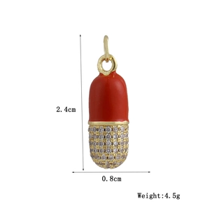 Detail of red enamel pill pendant with sparkling stones and size 2.4x0.8cm specs