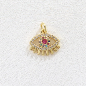 Macro view of gold-plated evil eye pendant with colorful zirconia pavé and red center stone