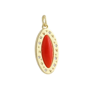 Macro detail of gold oval pendant featuring a red marquise stone and zircon accents