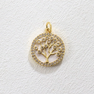 Macro shot of gold tree of life pendant with white zirconia inlay and pearl background