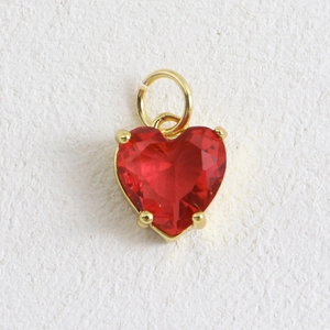 Détail d'un pendentif cœur en pierre rouge facettée avec bordure plaquée or 18 carats