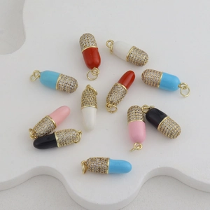 Detailed macro view of colorful capsule pendants with gold plating and cubic zirconia