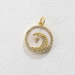 Detailed close-up of a crescent moon and star charm with pink inlay and zircon border