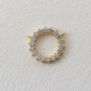 Macro view of gold jewelry connector ring featuring pave cubic zirconia and dual loops