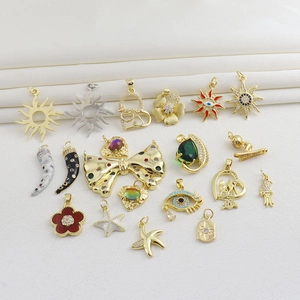 Détails macro des breloques soleil et cœur plaquées or 18 carats avec émail et zircons