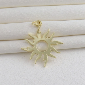Détail du pendentif soleil plaqué or 18k avec design évidé et rayons flamboyants