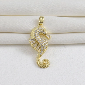 Detailed view of seahorse pendant in 18k gold plating with sparkling white zircons
