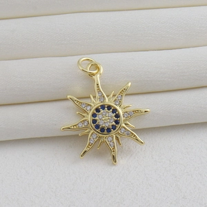 Détail d'un pendentif soleil plaqué or 18k avec zircons bleus et blancs sur un écrin