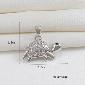 Macro shot of 18k gold turtle pendant with clear crystals, dimensions 1.8cm by 2.0cm