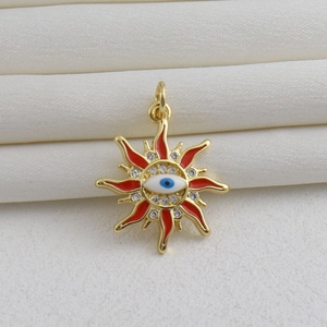 Vue macro du pendentif œil maléfique doré avec émail rouge et zircon sur de la soie