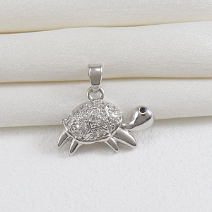 Detailed close-up of a silver sea turtle pendant with sparkling zircon inlays