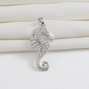 Detailed close-up of a silver-plated seahorse pendant with white cubic zirconia pavé setting