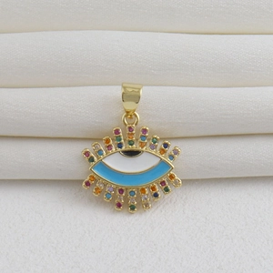 Macro de un colgante de ojo turco chapado en oro 18k con circonitas sobre seda blanca