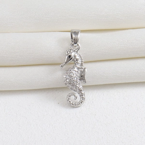 Detailed view of silver seahorse pendant with white crystal pavé and black gem eye