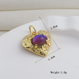 Détail d'un pendentif cœur 1,8x1,4cm en cuivre plaqué or 18k avec texture lave et gemme