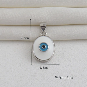 Detalle de colgante ojo de la suerte bañado en oro de 18k con medidas de 2,8 cm y 1,5 cm