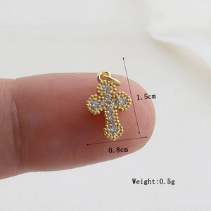Macro shot of gold cross pendant with micro-inlaid zircons showing size 1.5cm by 0.8cm