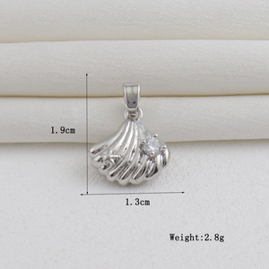 Detailed view of silver shell pendant with a clear zircon and measurement markings