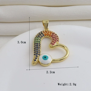 Detalle de colgante de corazón en oro de 18 quilates con gemas y ojo de la suerte
