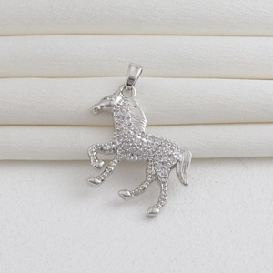 Detailed close-up of a 18k gold plated running horse pendant with crystal inlay