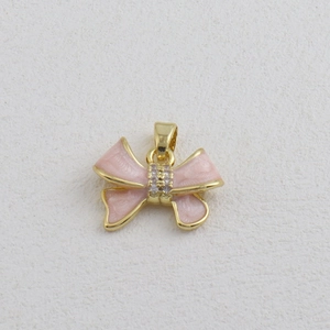 Detailed view of pink enamel bow pendant with gold plating and sparkling crystals
