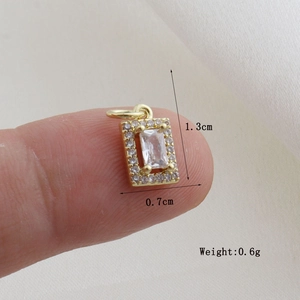 Macro detail of gold geometric pendant with zircon inlay showing 1.3cm size measurement