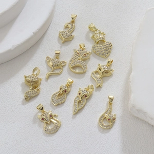 Macro detail of gold fox and heart crown charms with micro-pave white and red zircons