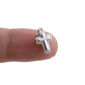 Polished silver cross pendant with spiral textured border and top connecting ring