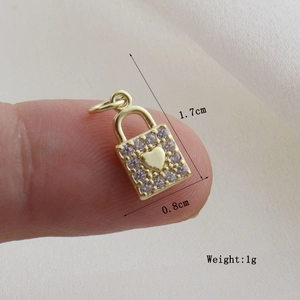 Macro view of a gold heart lock pendant with white rhinestones and size dimensions