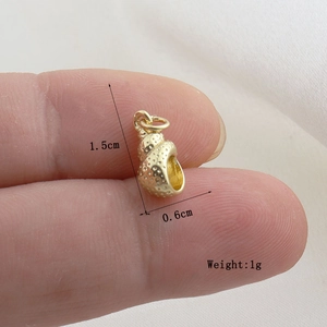 Detail of golden seashell pendant with textured dots and dimensions 1.5cm by 0.6cm