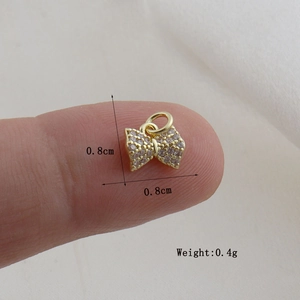 Detailed macro view of a gold-plated bow charm with white zircon micro-pave setting