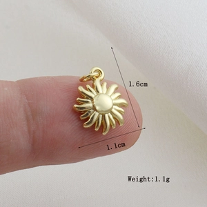 Dettaglio del ciondolo a sole dorato da 1,6 cm con misure mostrate sul dito