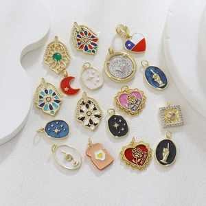 Macro shot of assorted gold-plated charms with colorful enamel details and zircon inlays