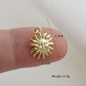 Dettaglio di un ciondolo a sole dorato da 1,6 cm con viso inciso per gioielli fai da te